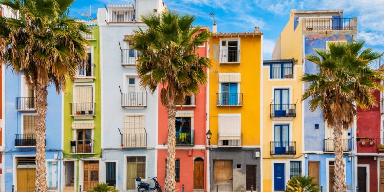 Foto desde la playa donde se puede ver las pintorescas casas que de colores que se encuentran en primera linea de playa