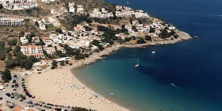 Foto de la playa de Torroella de Montgrí donde se puede ver la población al fondo de la playa sobre una pequeña colina sobre el mar