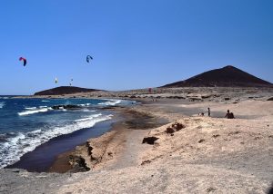 Foto de la playa del Médano con la Montaña Roja al fondo. Lugar perfecto para ir de vacaciones con tu perro