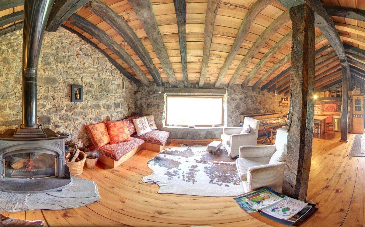Foto del interior de una cabaña de auténtico lujo con materiales de piedra y madera con chimenea y decoración rústica