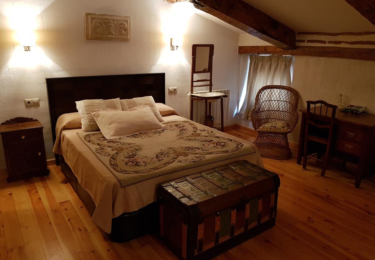 Interior de uno de los apartamentos que admiten perros en Cuenca con suelos de madera y techos rústicos